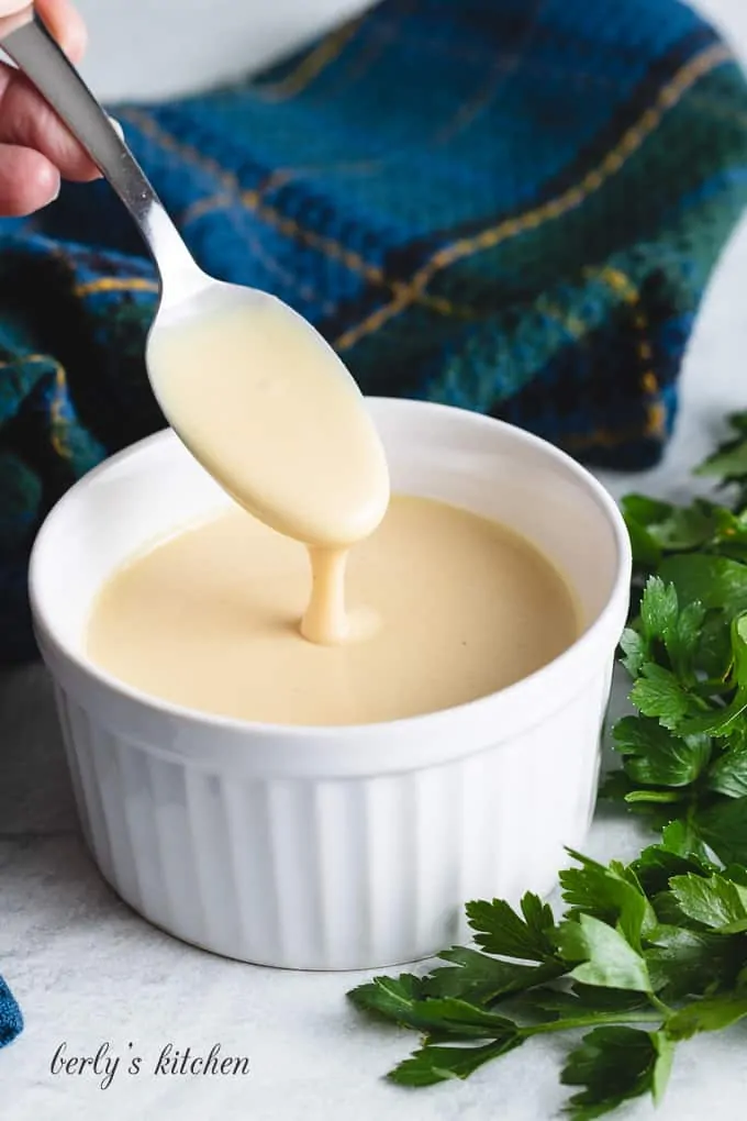 A small spoon being dipped into the sauce.