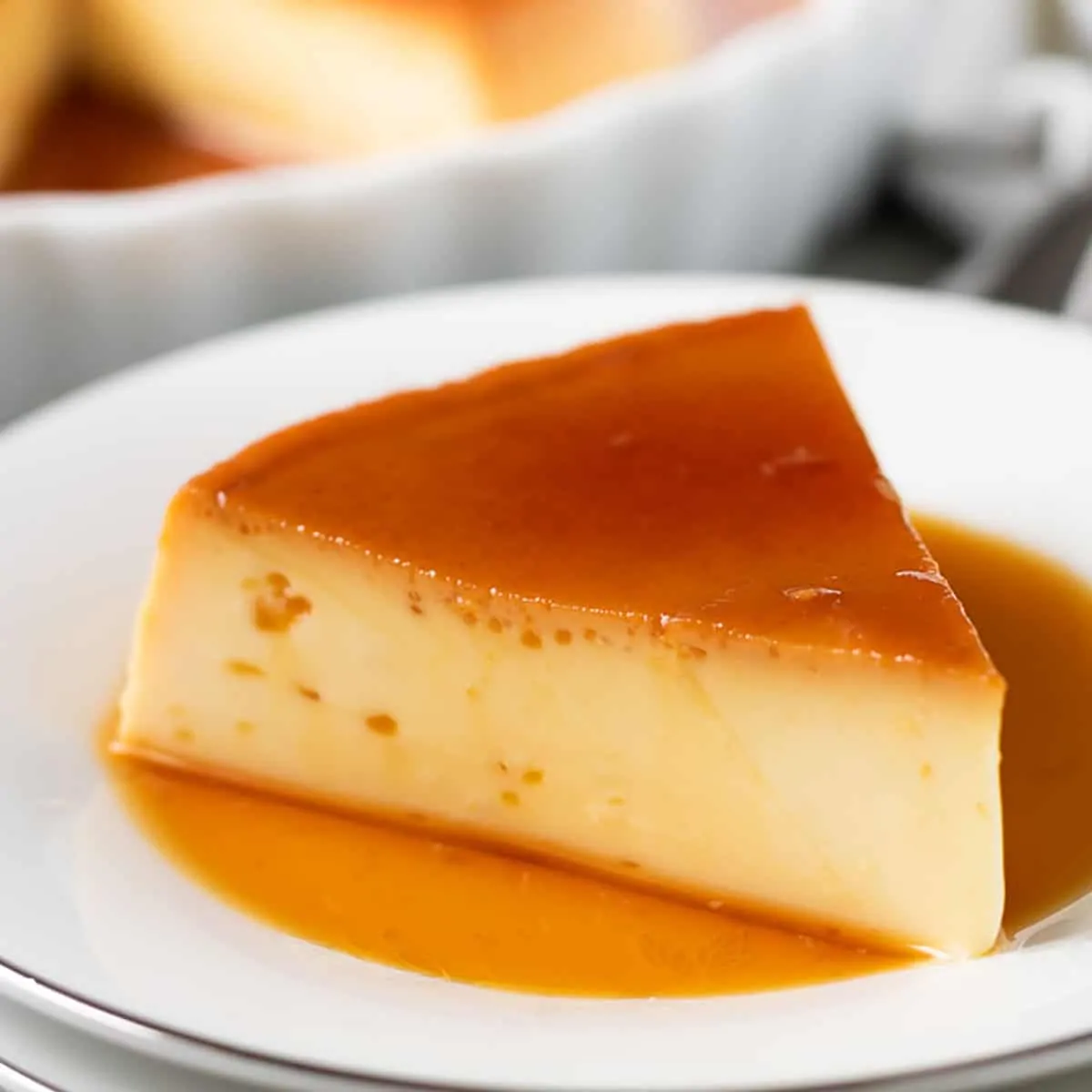 Instant pot flan slice with caramel sauce on a white plate.