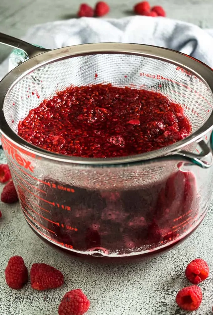 The syrup being strained into a measuring cup.