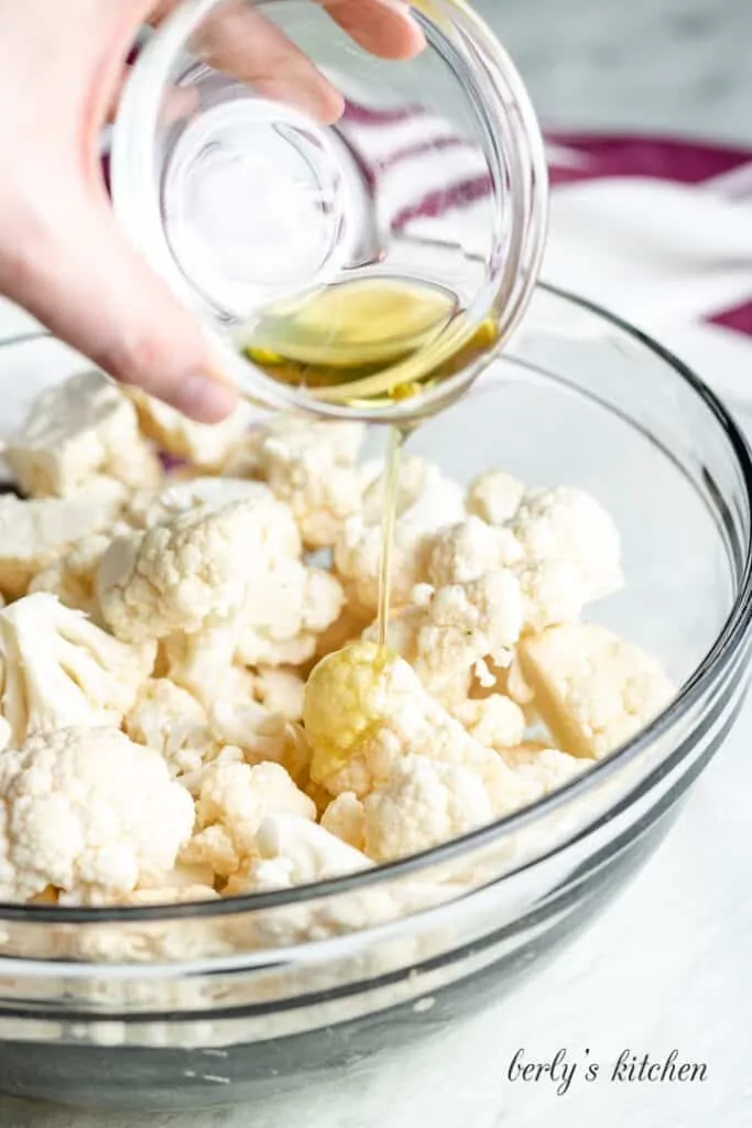 Avocado oil being poured over the cauliflower.