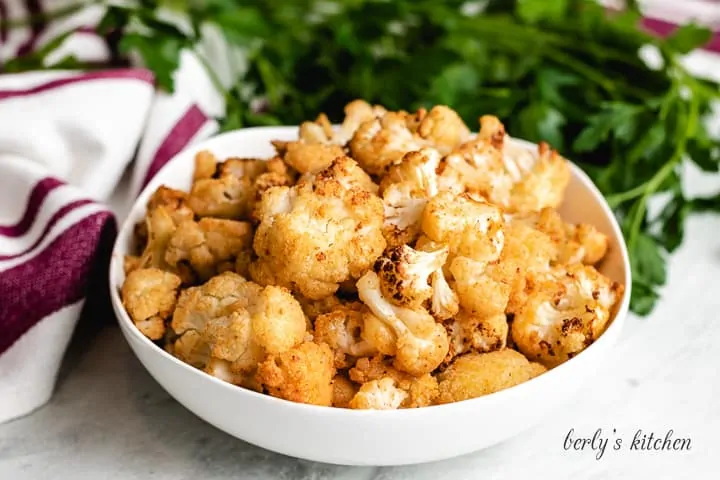 Seasoned air fryer cauliflower in a large bowl.