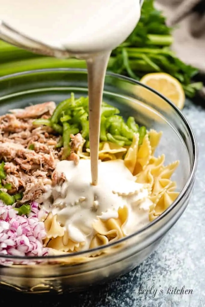 The dressing being poured over the salad ingredients.