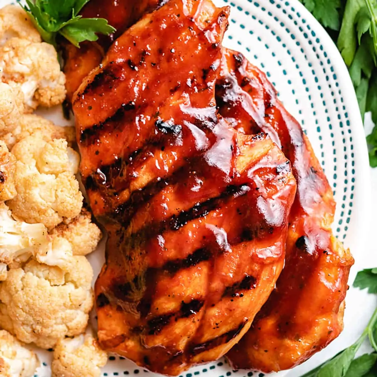 The grilled bbq chicken breast served with cauliflower.