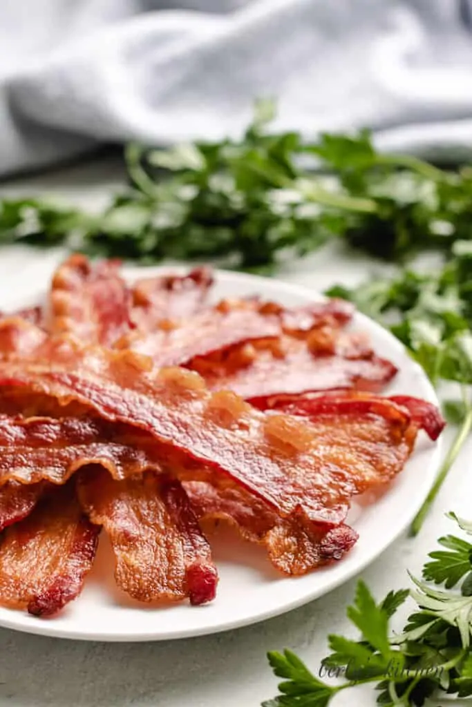 Strips of cooked bacon on a plate.