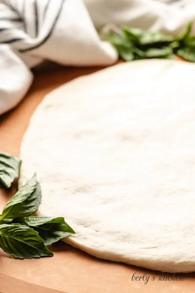 Raw pizza dough on a counter-top.