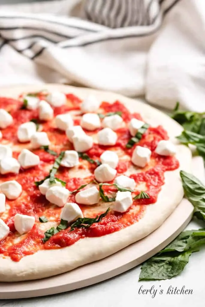 Thinly sliced fresh basil leaves added to the pizza.