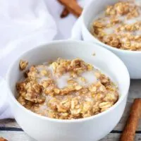 Two white bowls with cinnamon oatmeal.