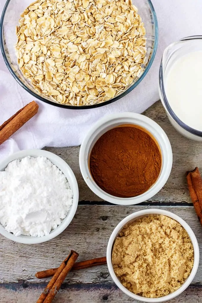 Top down view of ingredients for oatmeal (cinnamon, oats, milk, and brown sugar).