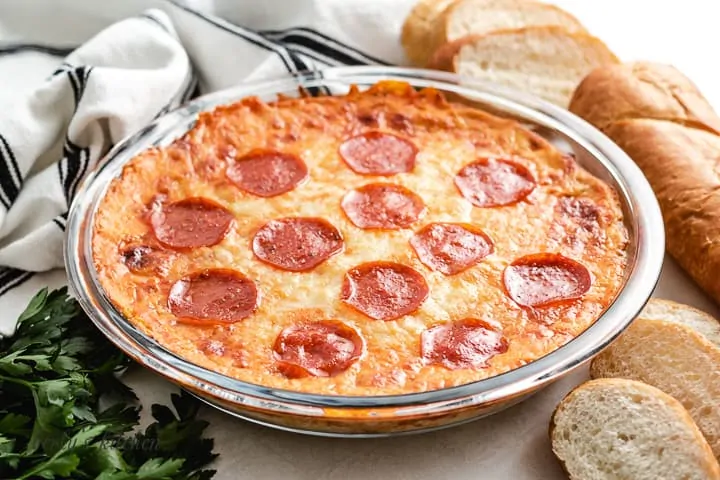 The baked pepperoni pizza dip in a pie pan.