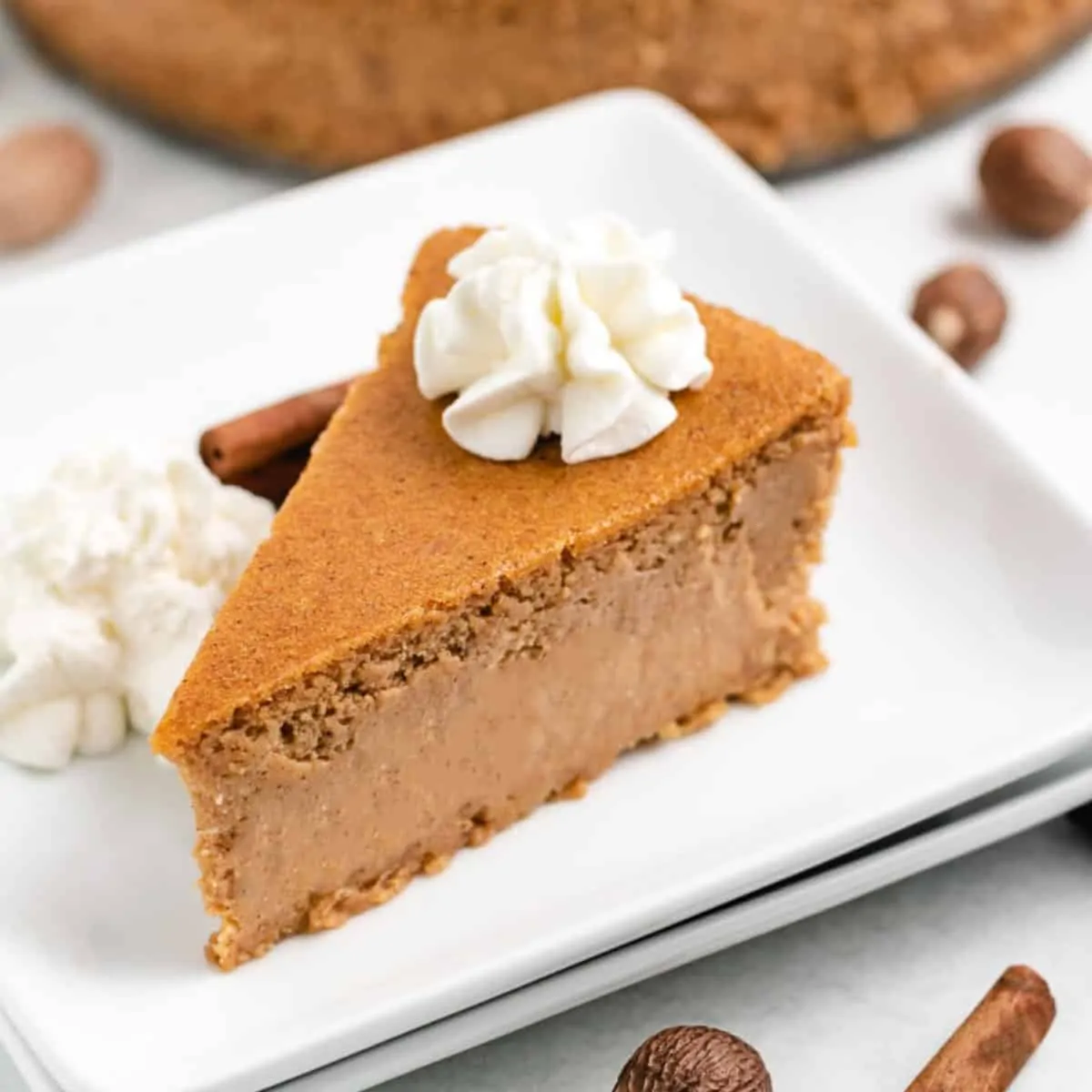 A big slice of pumpkin cheesecake on a plate.