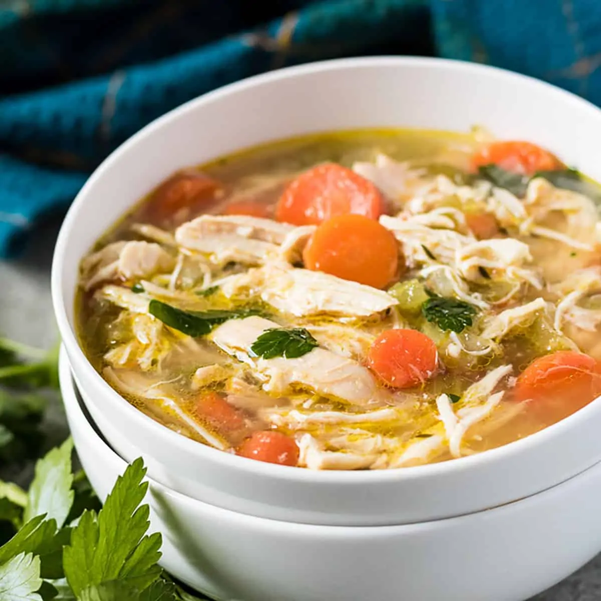 Two stacked bowls with chicken soup.