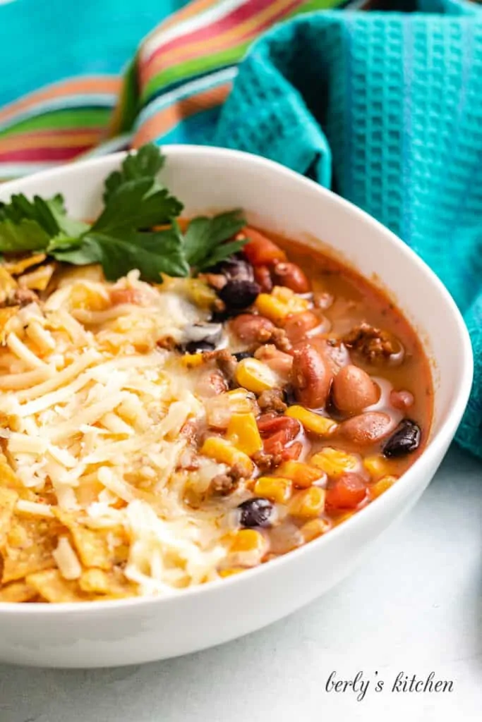 The bowl of soup surrounded by decorative towel.