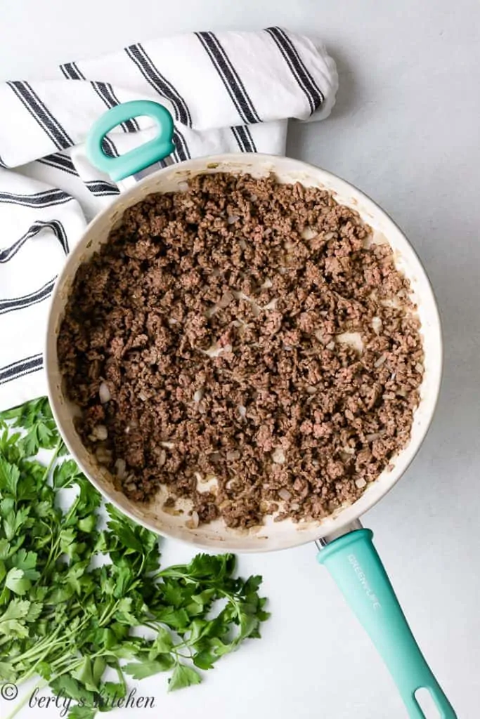 The ground beef cooking in the saucepan.