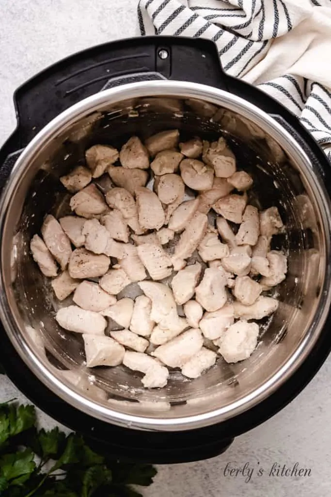 Chopped chicken cooking in the pressure cooker.