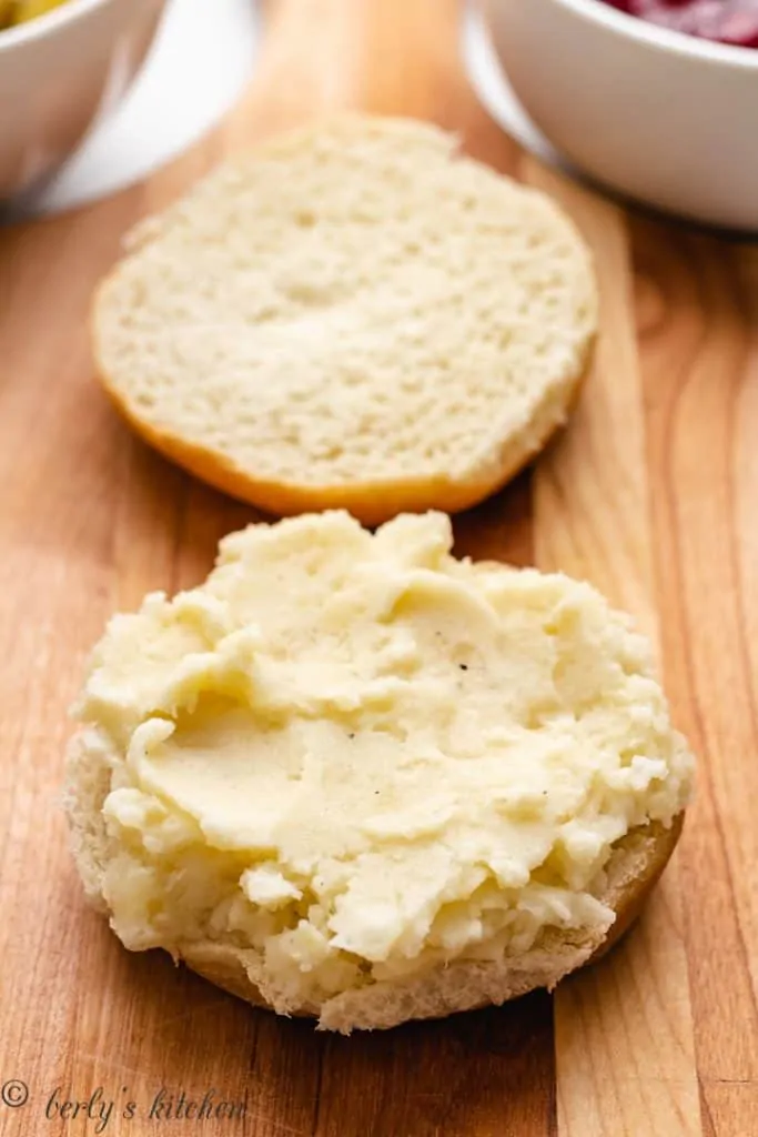 Mashed potatoes spread out on a bun.