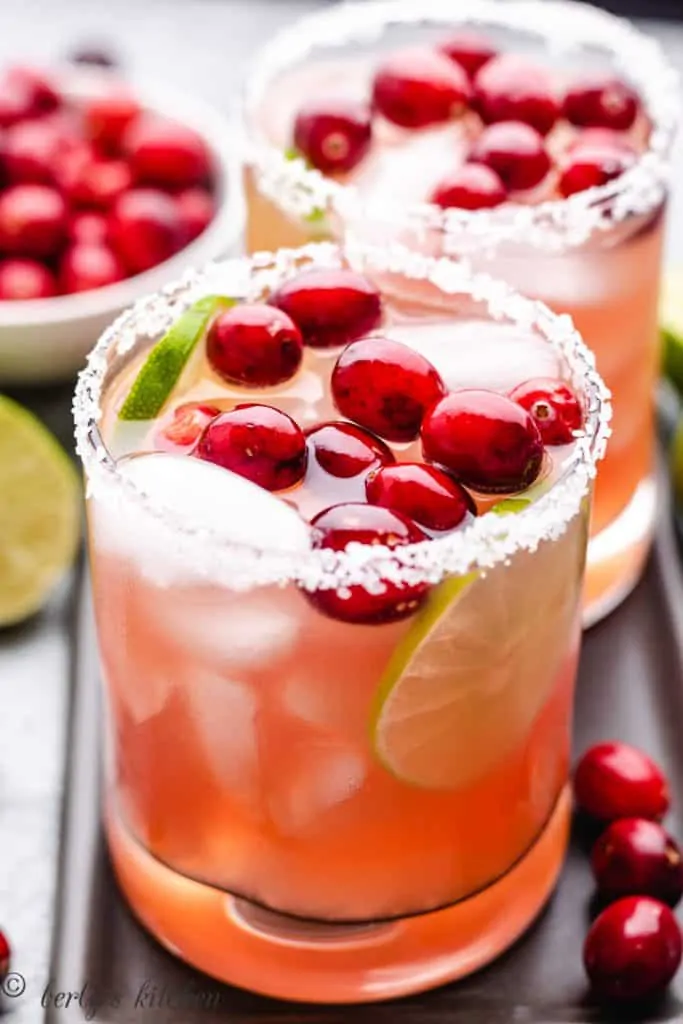 Cranberry margaritas in glasses garnished with fresh cranberries.