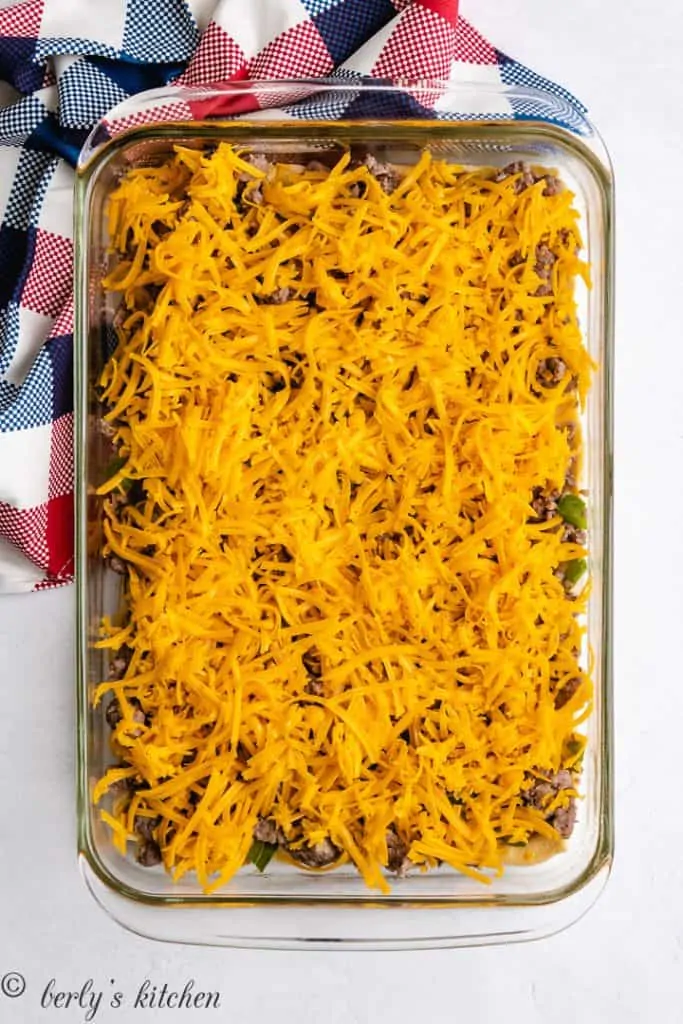 The sausage mixture and cheese layered into the dish.