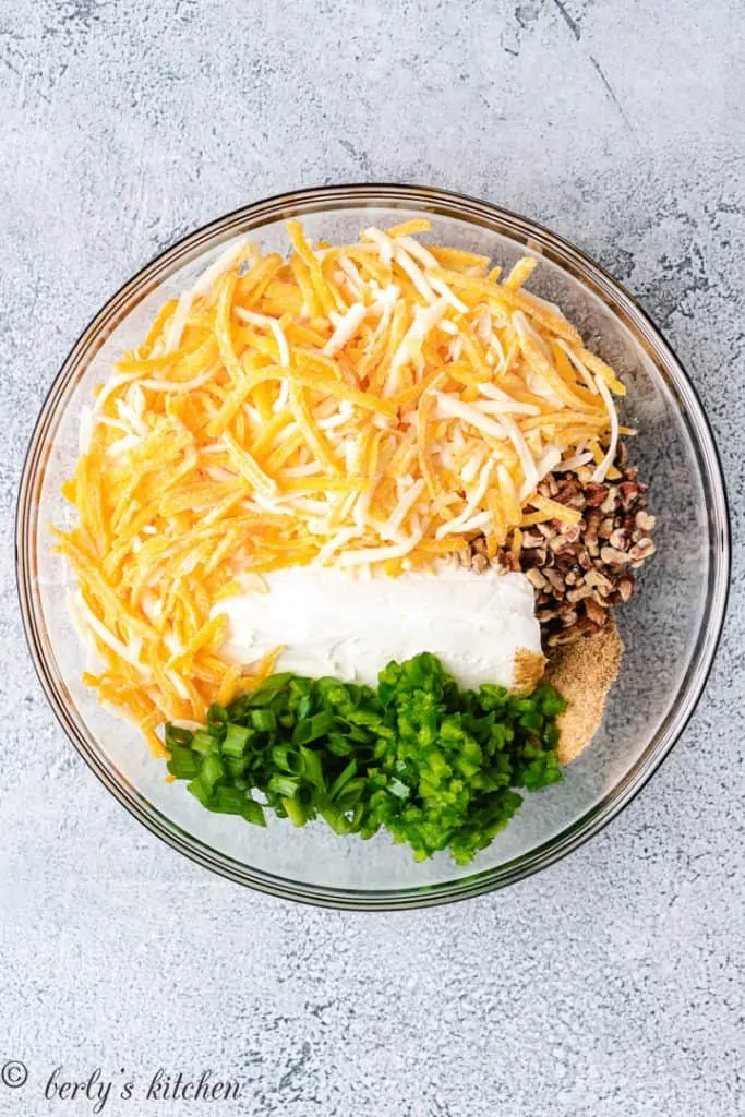 Cream cheese, peppers, and other ingredients in a mixing bowl.