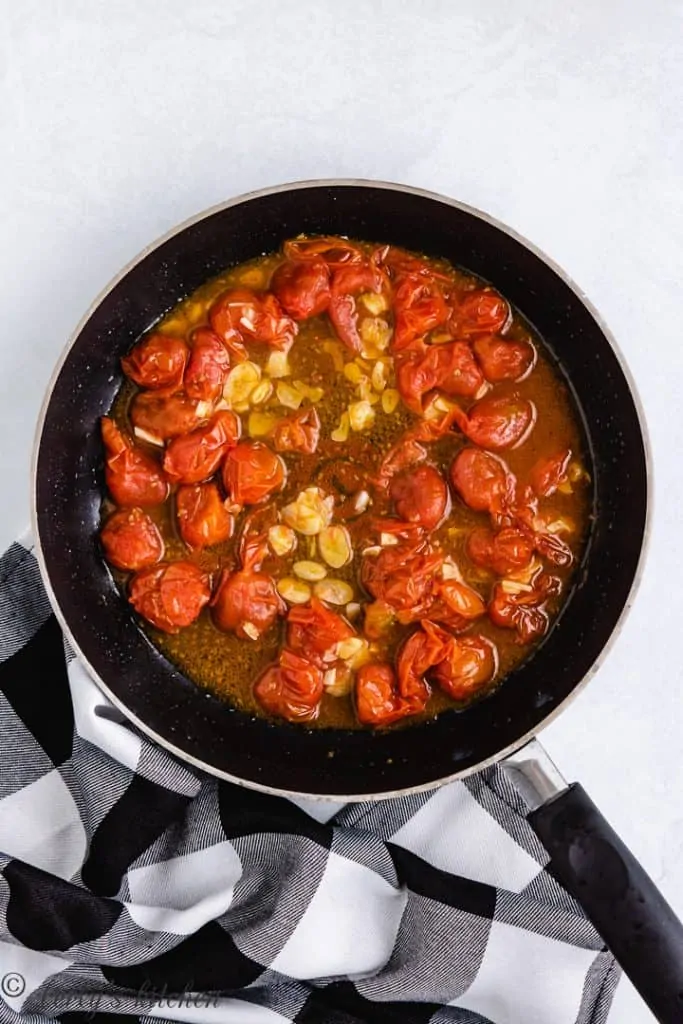 Tomatoes, garlic, and broth cooking in the pan.