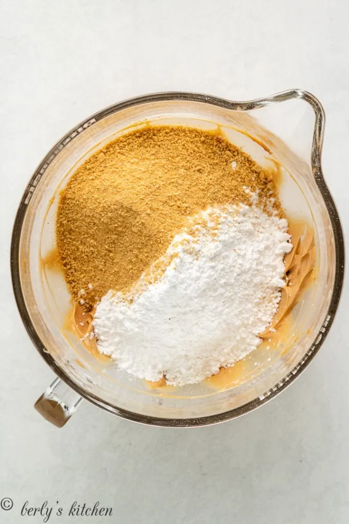 Powdered sugar and graham cracker crumbs added to the mixing bowl.