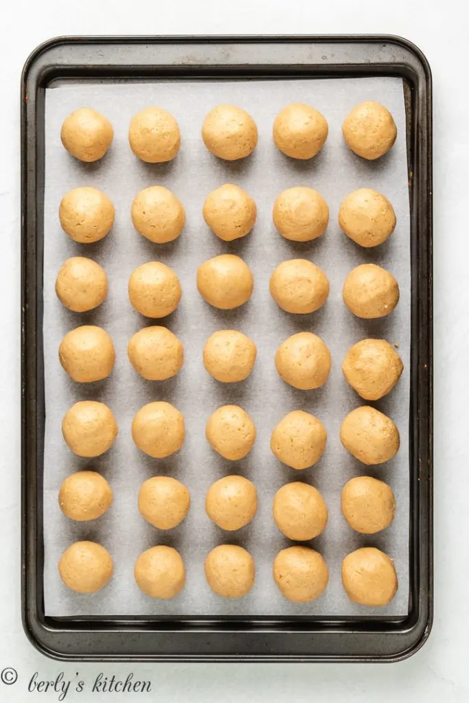 Truffle filling rolled into balls and placed on a lined baking sheet.