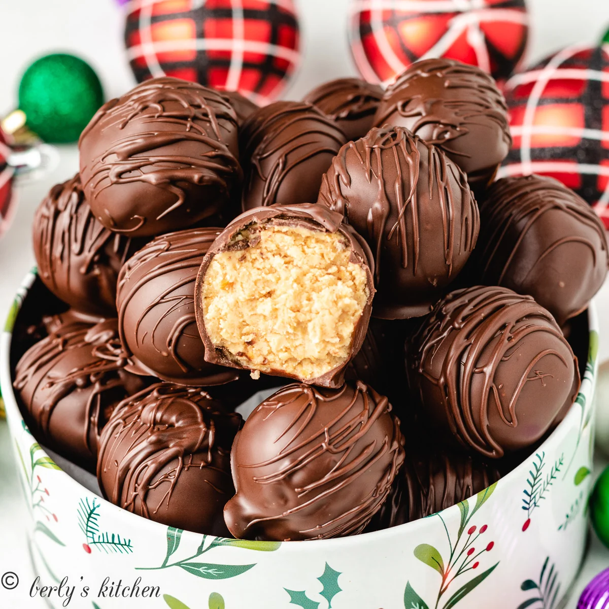 The chilled peanut butter balls in a decorative holiday tin.