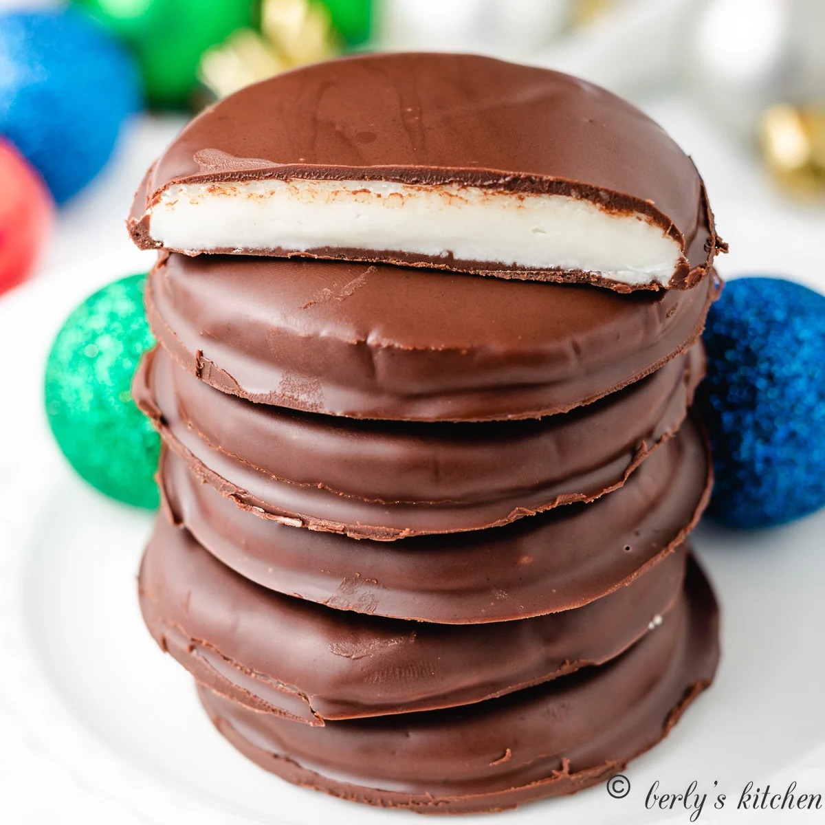 Six peppermint patties stacked on a plate.