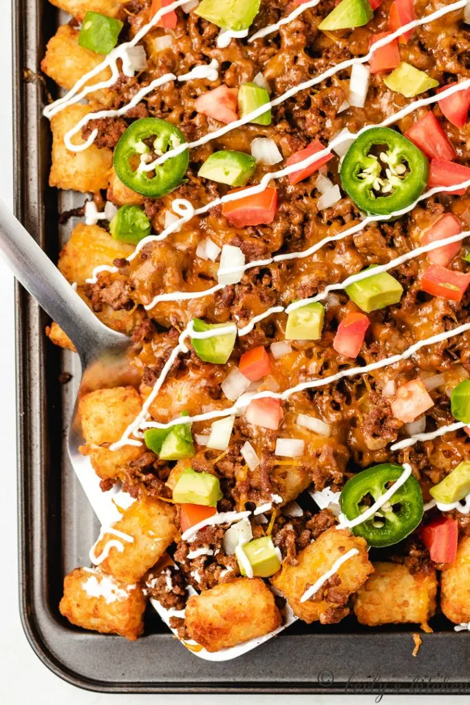 Close up view of tater tot nachos on a pan.