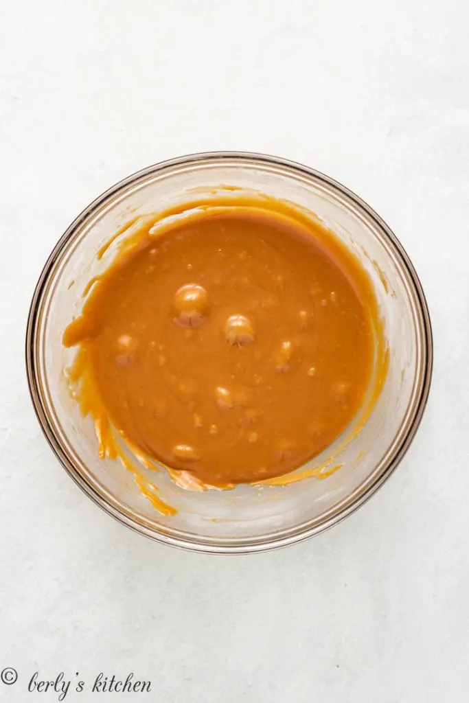 Melted caramel in a glass mixing bowl.