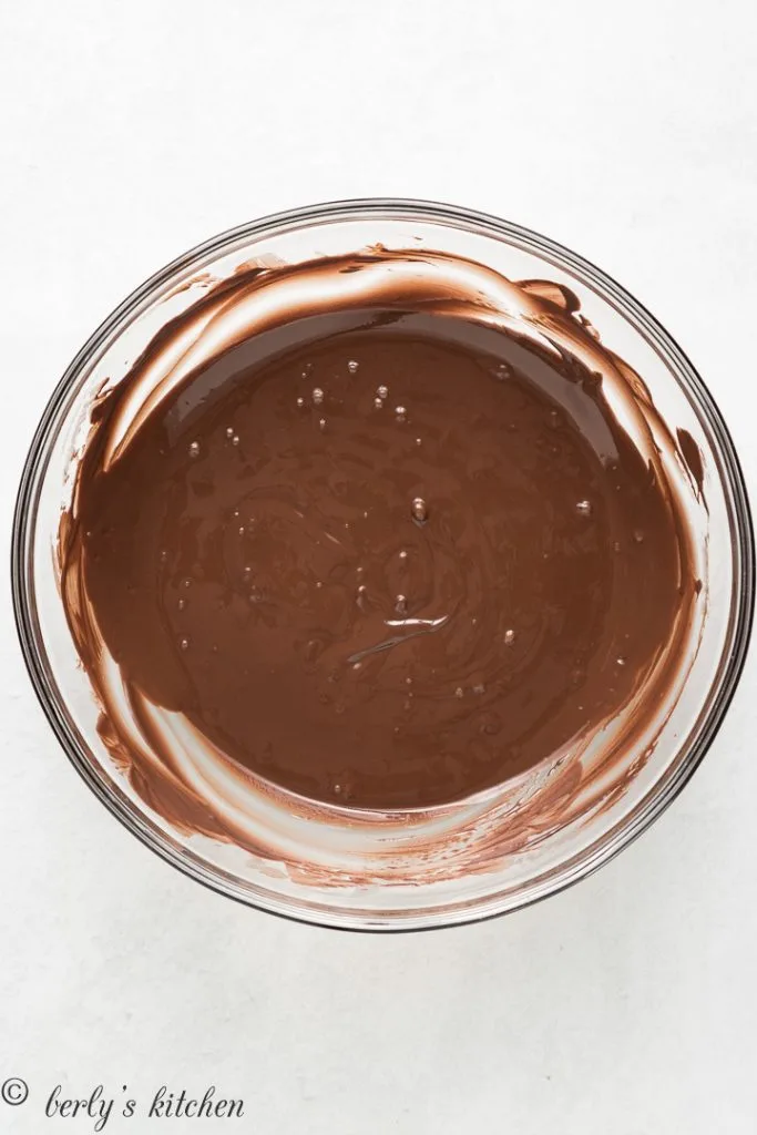 Melted chocolate in a glass mixing bowl.