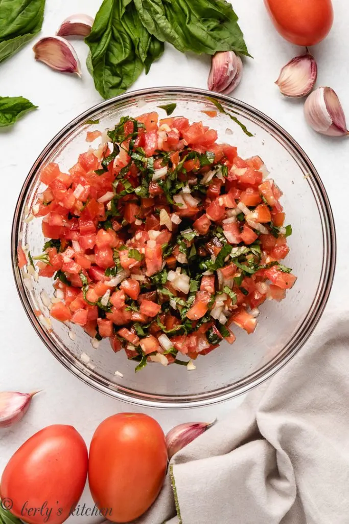 Bruschetta ingredients in a glass bowl.