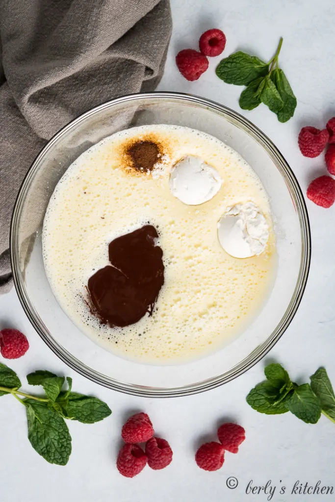 Eggs, sugar, melted chocolate, and flour in a bowl.