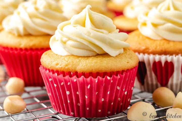 Close up of a yellow cupcake with white chocolate frosting.