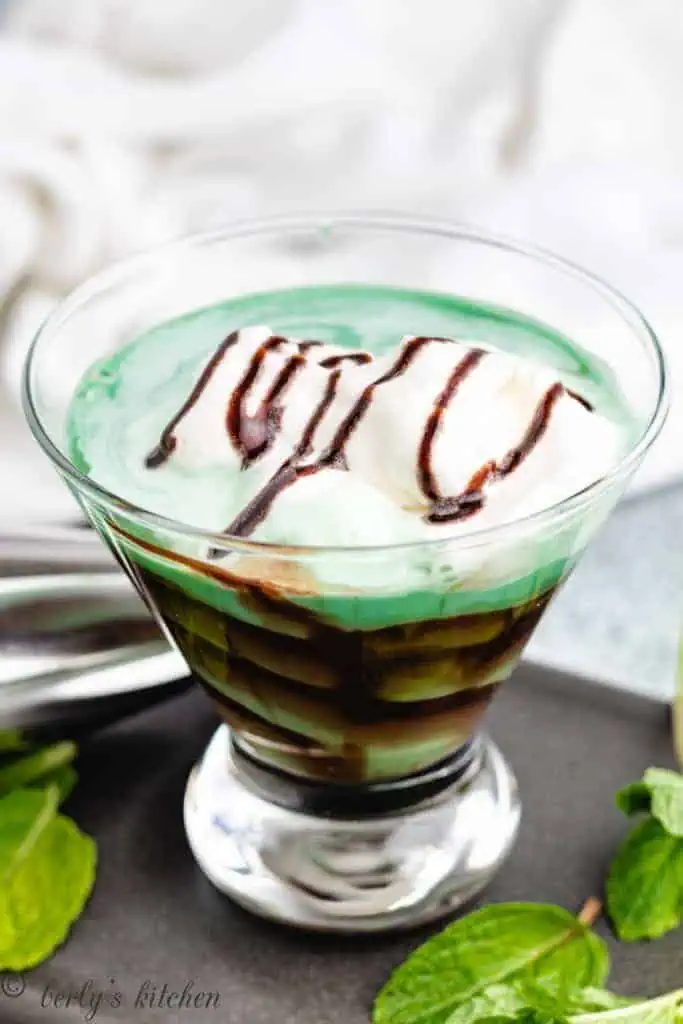 Grasshopper drink topped with whipped cream and chocolate syrup.