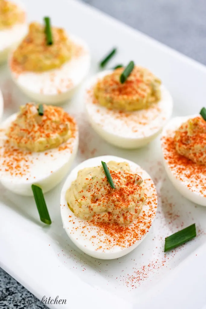 Several deviled eggs topped with diced green onions.