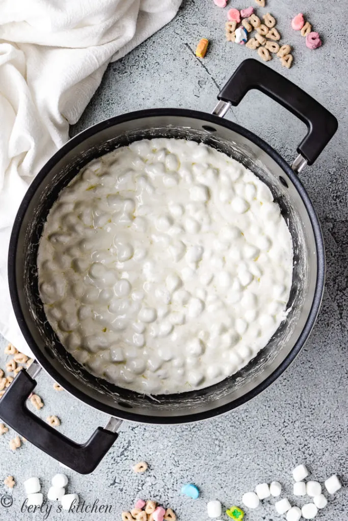 Partially melted marshmallows in a black pan.