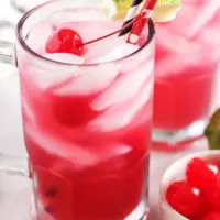 Cherry limeade served in a large mug with a colorful straw.