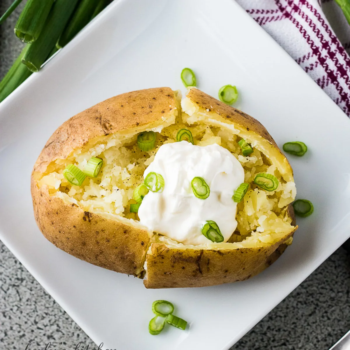 Top down view of instant pot baked potatoes with a scoop of sour cream.