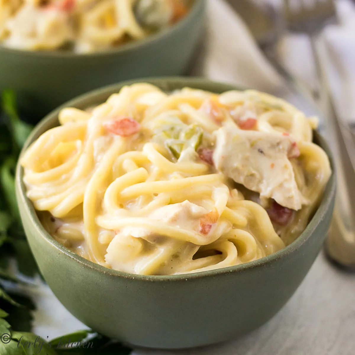 Instant pot chicken spaghetti in green bowls.