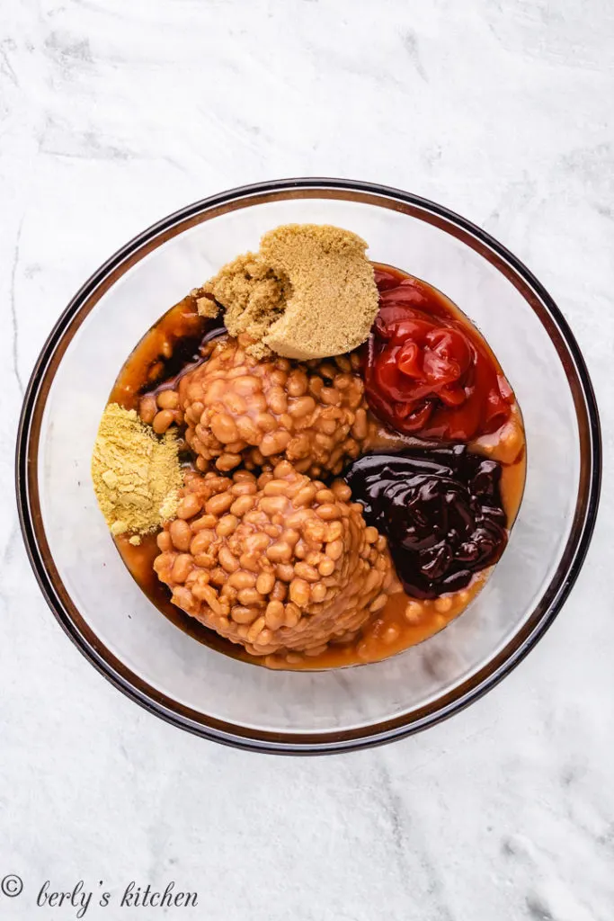 Baked beans and seasonings separated in a bowl.