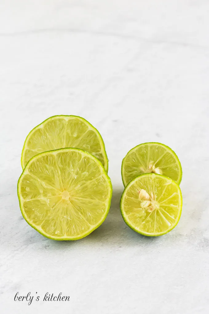 Key limes cut in half and stacked next to each other.