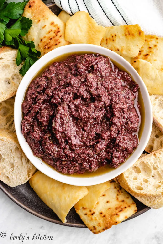 Olive dipping spread with chips and toast.