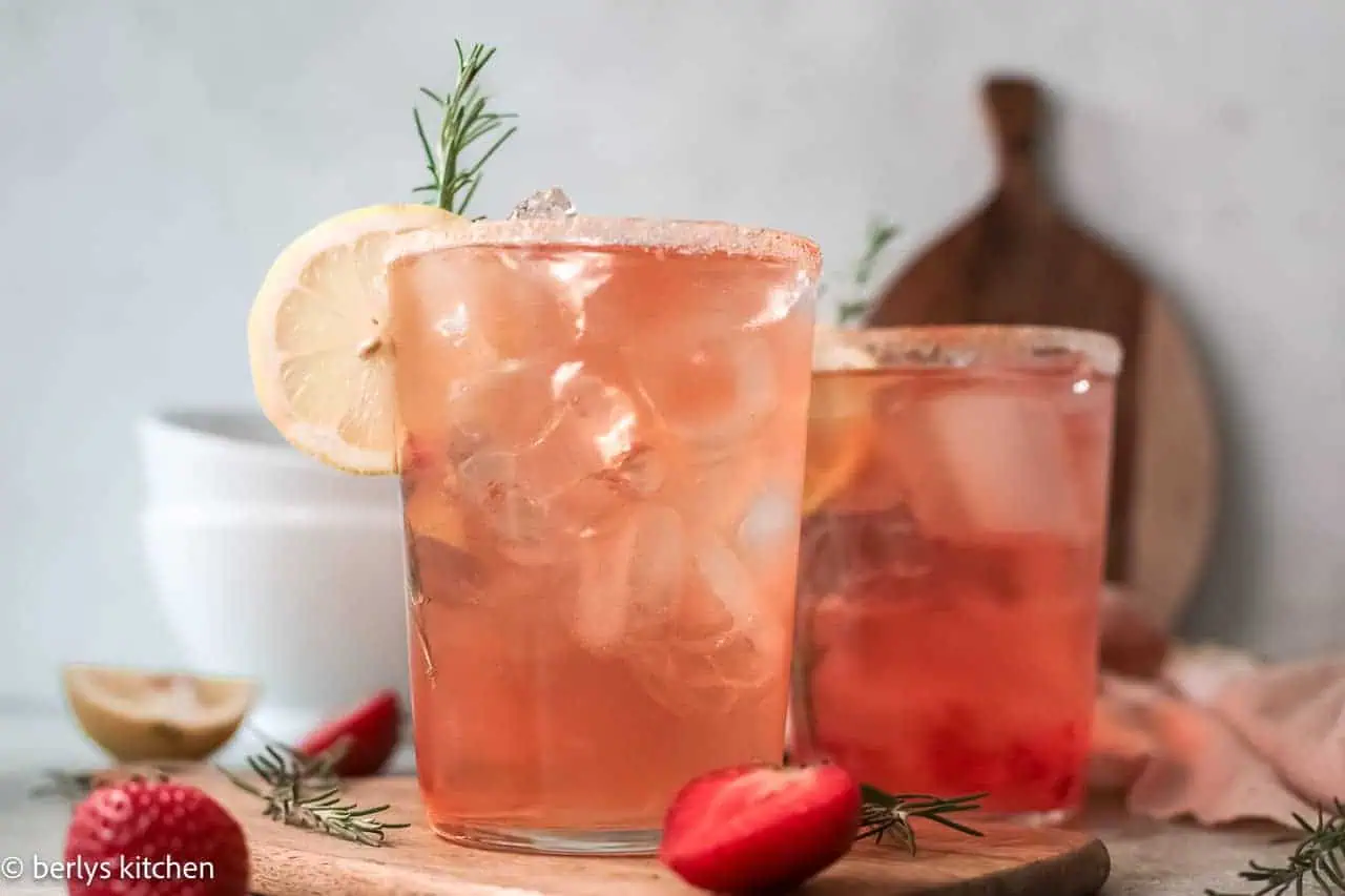 Two glasses of strawberry cocktail with lemon slice.