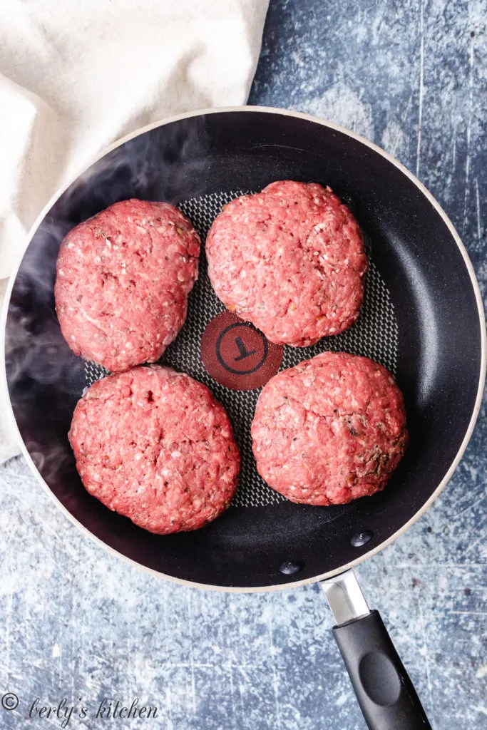 Top down photo of 4 raw burger patties.