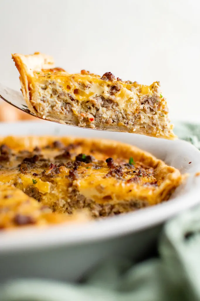 Slice of quiche on a spatula.