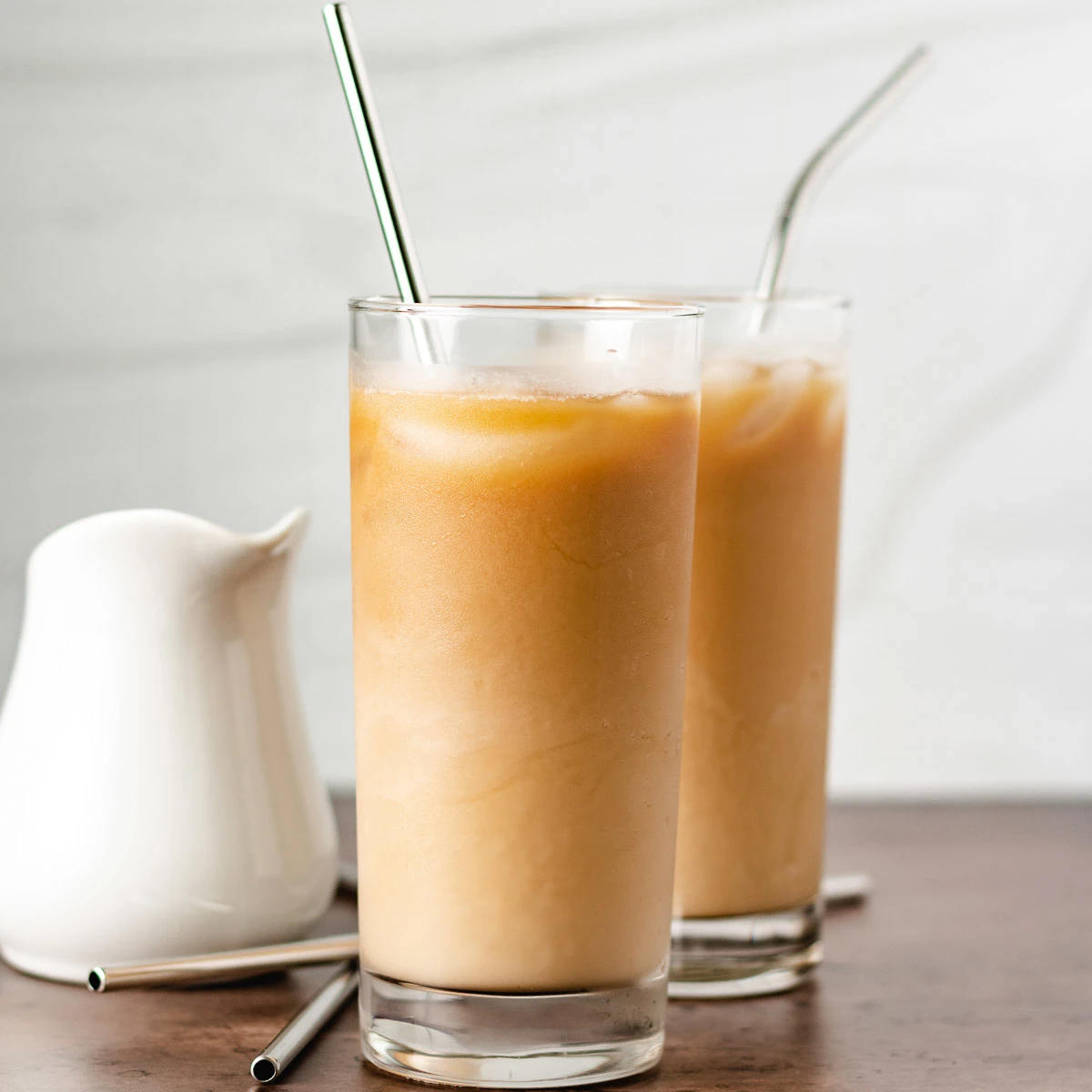 Two highball glasses filled with caramel coffee.