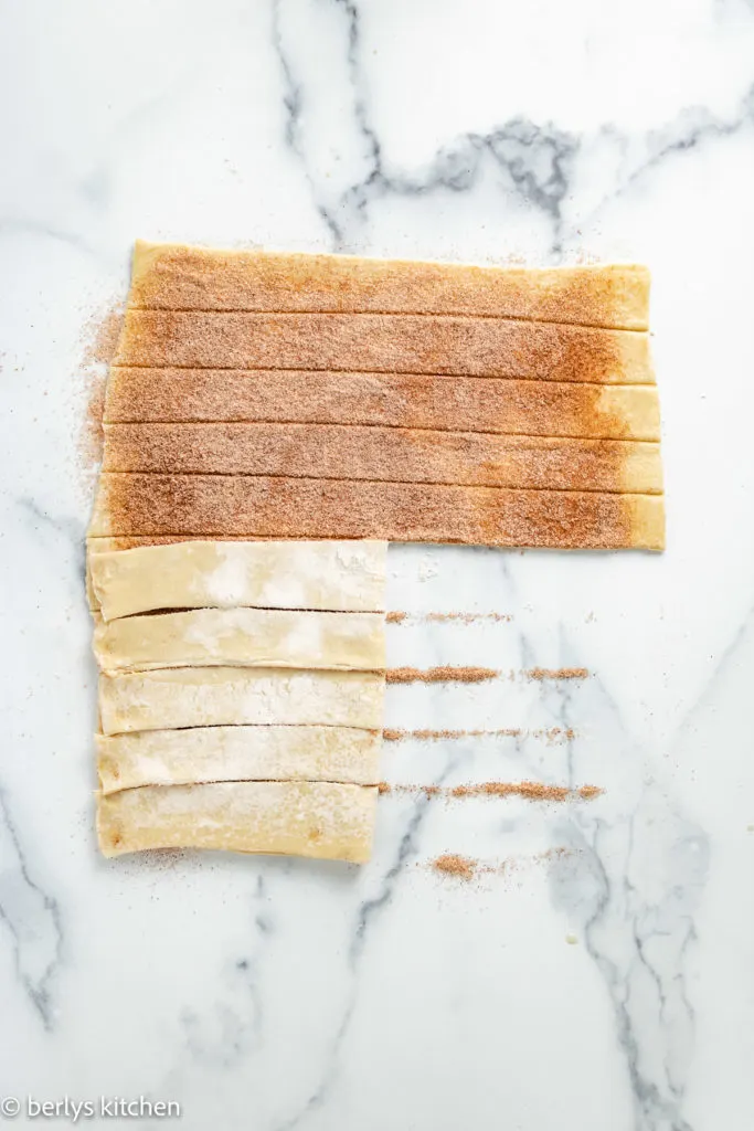 Dough with cinnamon sugar being twisted.