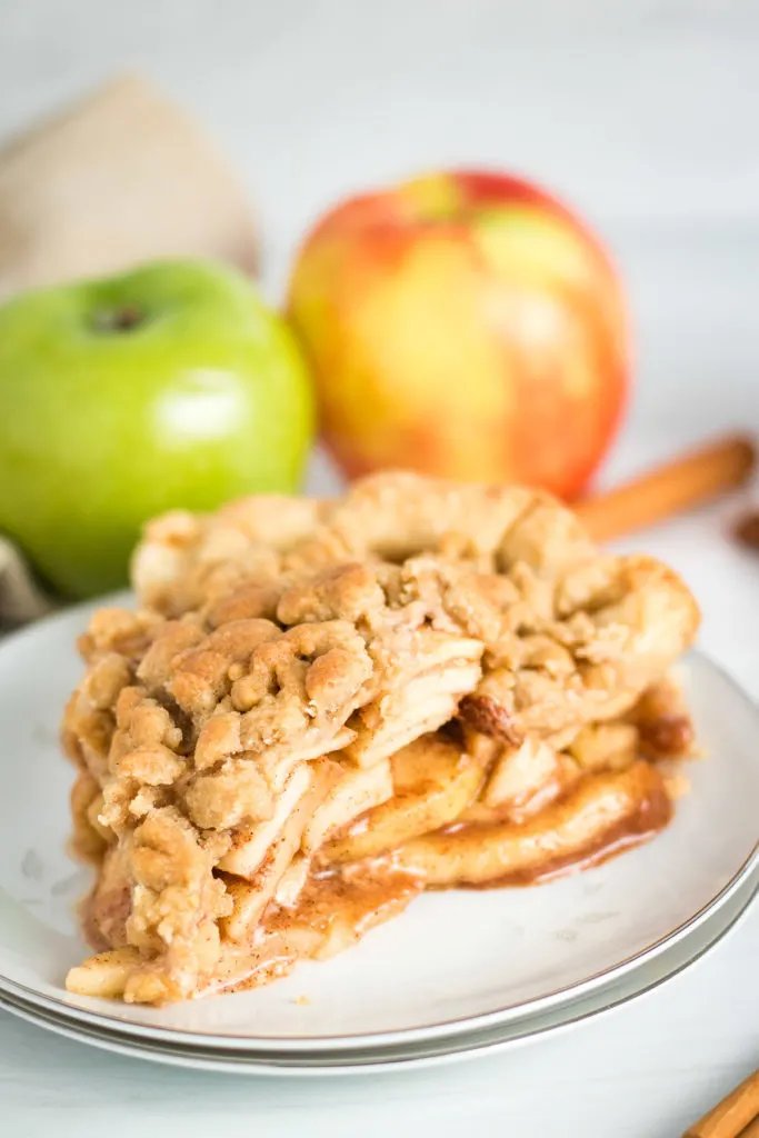 Slice of dutch apple pie on a white plate.