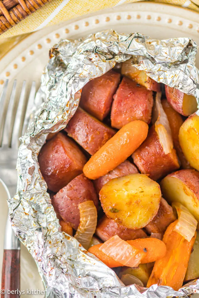 Top down view of sausage potato carrot foil packet.