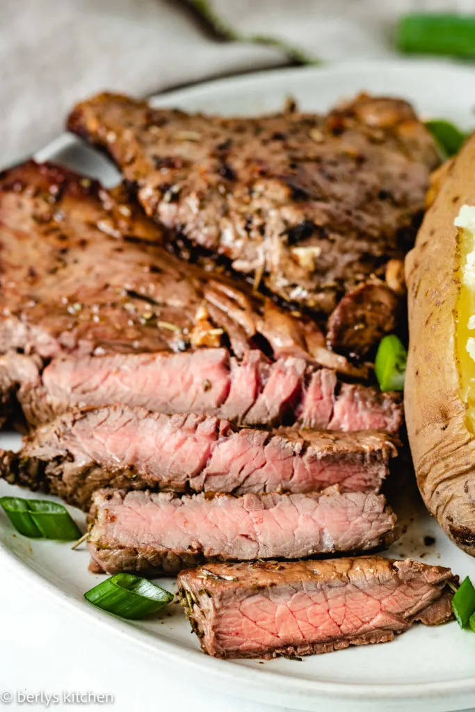 Close up of sliced sirloin steak on a plate.